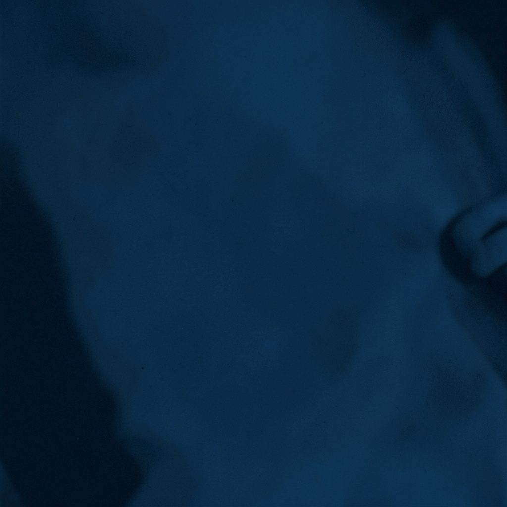 Soft navy duotone image suggesting a conference gathering of specialists in a bright hall
